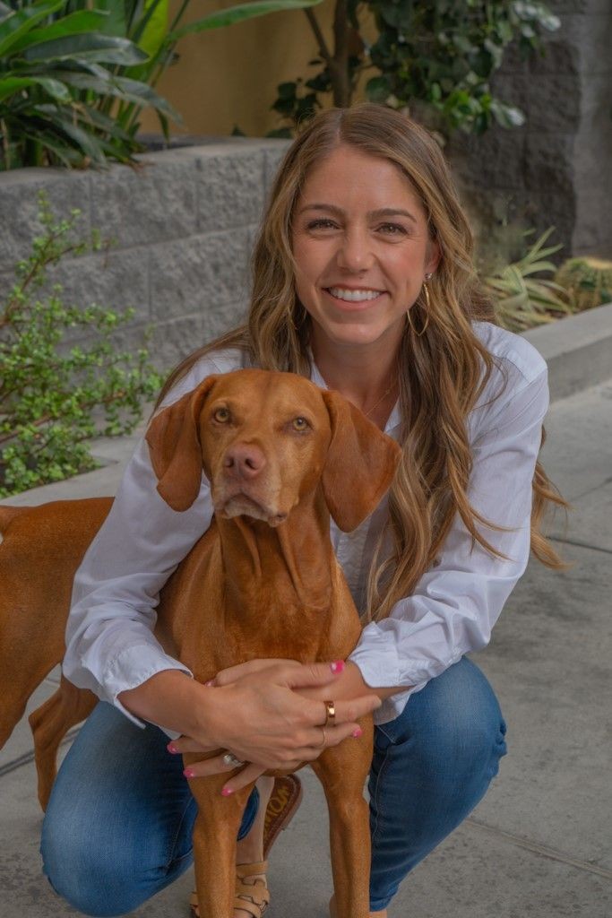 Happy owner holding service dog on sidewalk outside